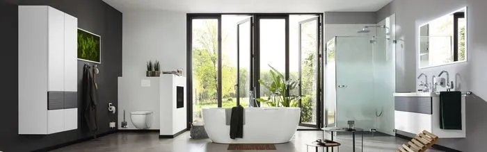 Modern bathroom with large windows opening to greenery. Features a freestanding tub, glass shower, double sink, and sleek cabinets. Bright and serene.